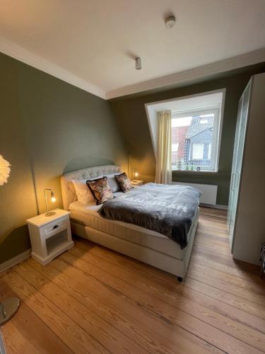 1 dormitorio con cama y ventana en Schöne große 4 Zimmer-Altbauwohnung en Kiel