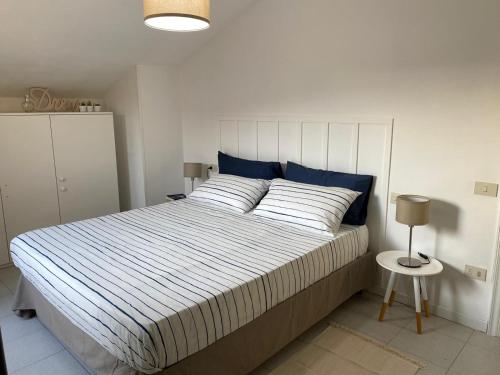 a bedroom with a large bed with blue pillows at La Casa BluMare in Porto Recanati