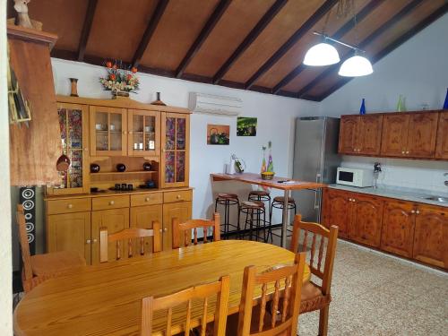 a kitchen with a wooden table and a kitchen with a refrigerator at Mirador Vista Palacios in San Sebastián de la Gomera