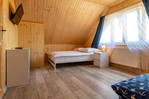 a small bedroom with a bed and a window at Przystanek Mewa in Rozewie