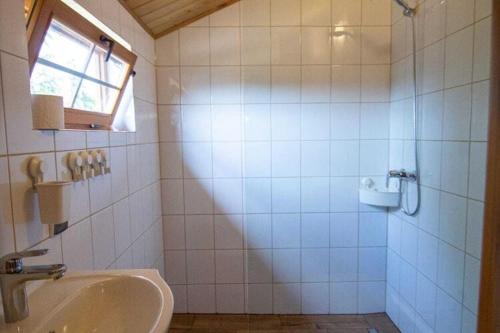 a bathroom with a sink and a shower with a window at Bungalow, Miedzyzdroje in Międzyzdroje