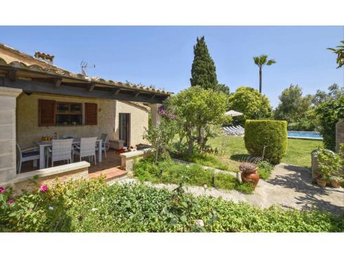 une maison avec un jardin doté d'une table et de chaises dans l'établissement Belvilla by OYO Tonina, à Pollença