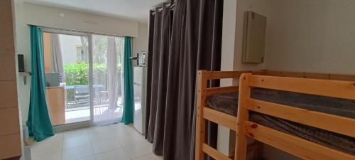 une chambre avec un lit et une fenêtre avec un balcon dans l'établissement Beau STUDIO de 27m au centre de FREJUS !, à Fréjus