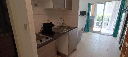 une petite cuisine avec un évier et une fenêtre dans l'établissement Beau STUDIO de 27m au centre de FREJUS !, à Fréjus