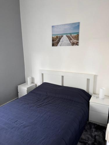 a bedroom with a blue bed and a picture on the wall at Casa Amarela in Loulé