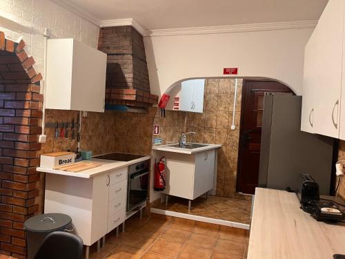 eine Küche mit weißen Schränken und einem Waschbecken in der Unterkunft Casa Amarela in Loulé