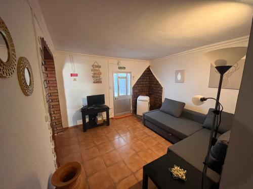 a living room with a couch and a television at Casa Amarela in Loulé