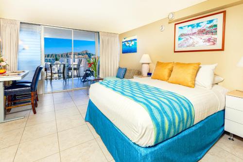 ein Hotelzimmer mit einem Bett, einem Schreibtisch und einem Balkon in der Unterkunft Escape to Paradise, Ocean & Diamond Head View Studio in Waikiki! in Honolulu