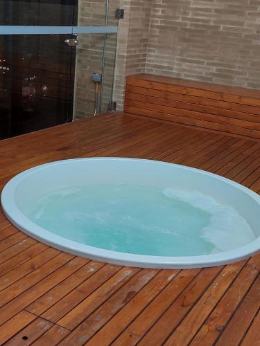 a large bath tub sitting on a wooden deck at TOSCANO S Aparta Estudio Hospedaje Amoblado Torre 2 Equilibrium in Bogotá