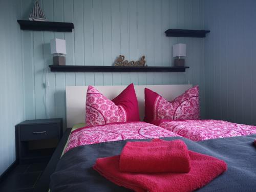 sypialnia z łóżkiem z różowymi poduszkami w obiekcie Bungalow Ulf w mieście Lauchhammer