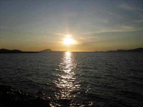 a sunset over a body of water with the sun setting at Sea View, 1st Floor, Harbour Mill, Westport Quay in Westport