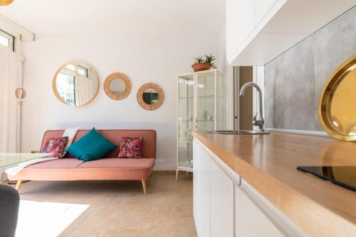 a kitchen with a pink couch and a sink at Quality and peaceful stay in Playa del Inglés in Playa del Ingles