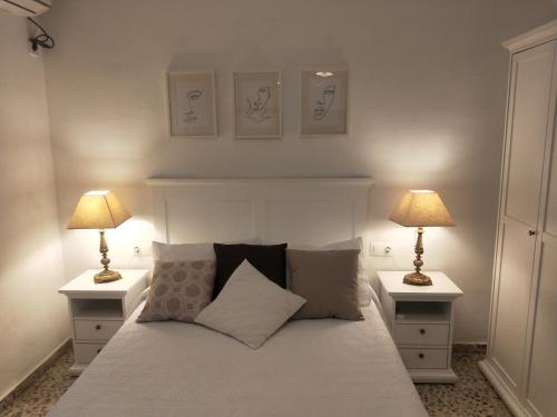 een slaapkamer met een bed met twee lampen op tafels bij Casa en pueblo con piscina cerca de Córdoba in Encinarejo De Córdoba
