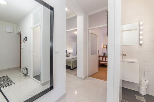 a bathroom with a mirror and a room with a bed at Apartman Porto in Ploče