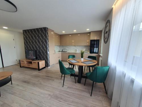 a dining room with a table and green chairs at 2-bedrooms apartment in city center Šiauliai in Šiauliai