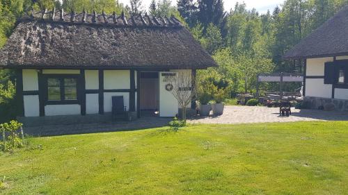 una casa blanca y negra con un patio de césped en Hinnedal ,på Ryssberget, en Näsum