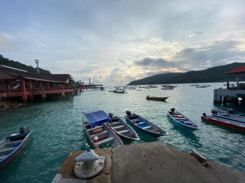 a group of boats in the water near a dock at Perhentian Hazipah in Perhentian Island