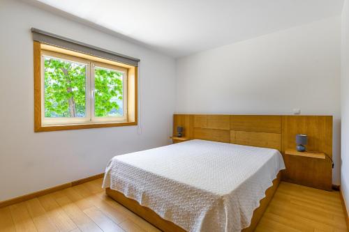 ein Schlafzimmer mit einem weißen Bett und einem Fenster in der Unterkunft Escolinha de France in France