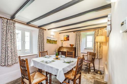 a dining room with a table and chairs and a piano at Old Dame School in Bainbridge