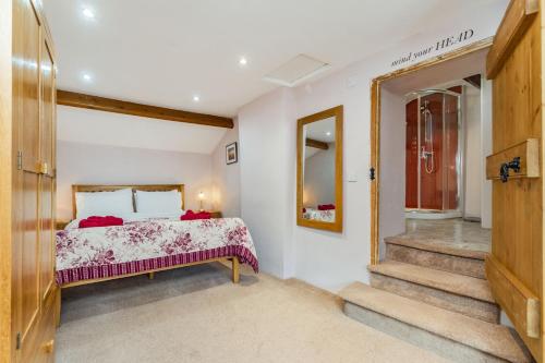 a bedroom with a bed and a mirror and stairs at Old Dame School in Bainbridge