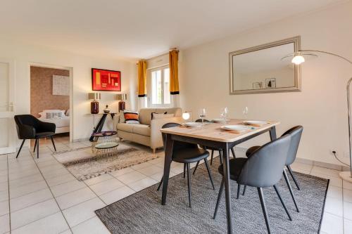 a dining room and living room with a table and chairs at The Parc des Raisses - T2 for 4 people in Annecy