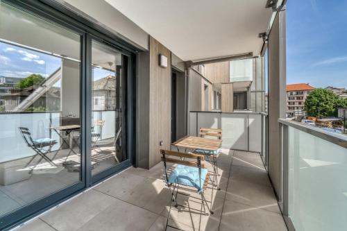 un balcon avec une table et des chaises sur un immeuble dans l'établissement Emergence - Beau T1 pour 2 personnes balcon et garage, à Annecy