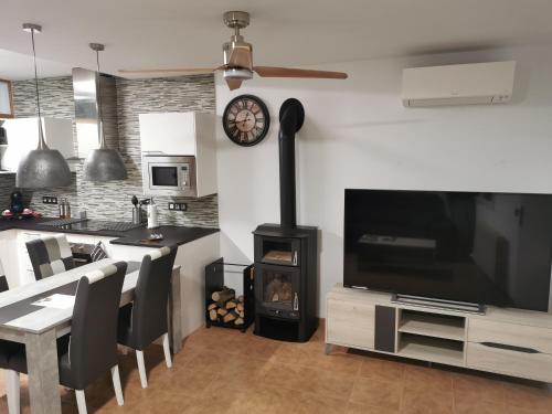 sala de estar con fogones y TV y cocina en Loft romàntic Ca l'Enric Viqué-Baix Empordà, en Regencós