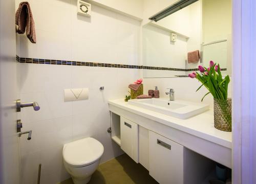 a white bathroom with a toilet and a sink at Lavica Bellevue apartments & studios in Podstrana