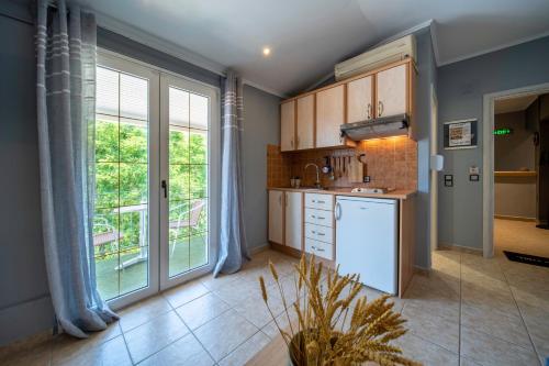 eine Küche mit einem weißen Kühlschrank und einem Fenster in der Unterkunft Helen's Studios & Apartments in Skala