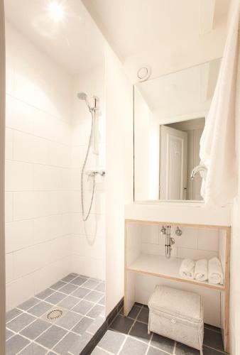 a white bathroom with a shower and a sink at Dahli's Sleep Boutique in Amsterdam