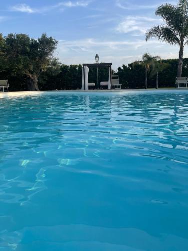 a swimming pool with a fountain in the background at Masseria Giamarra in Carpignano Salentino