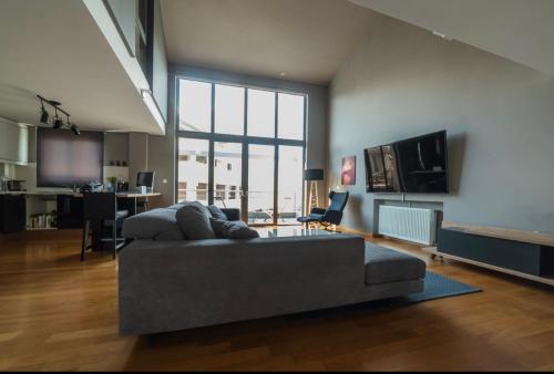 a living room with a couch and a television at Minimal Brand New Loft next to Subway in Athens