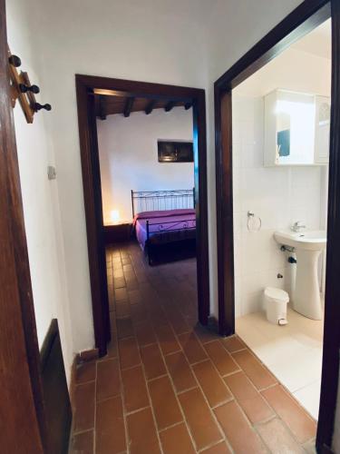 a hallway with a bathroom with a sink and a toilet at Agriturismo “Sterrati” in Valpiana