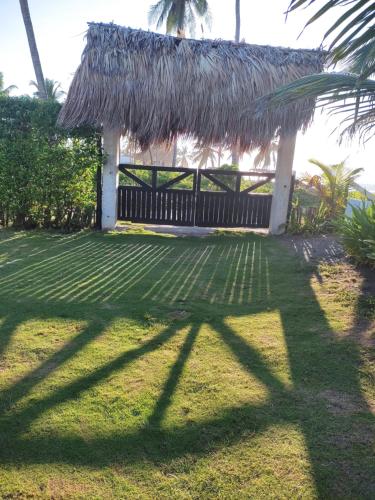 a house with a thatched roof and a grass yard at AGUAMARINA House in San Bernardo del Viento