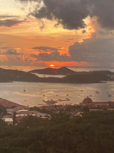 a sunset over a harbor with boats in the water at Boundless Bliss Hotel in St Thomas