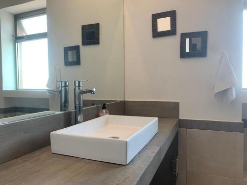 坎昆的住宿－Cancún Airport Zone，浴室设有白色水槽和镜子