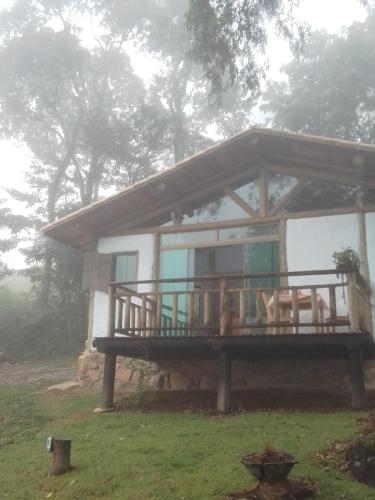 a small house with a porch and a deck at chale opucv in Gonçalves