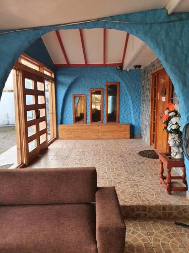 Residencial mi Casa في أولموي: غرفة معيشة مع أريكة والجدار الأزرق