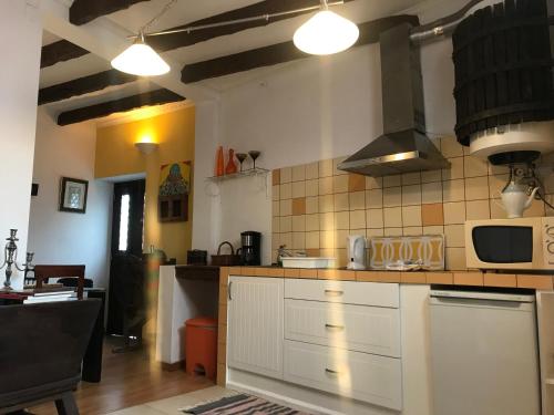a kitchen with white cabinets and a microwave at Casa do Poço Funchal in Funchal