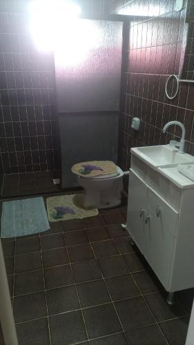 a bathroom with a toilet and a sink at Pousada Cama & Café in Navegantes