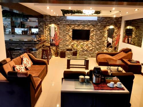 a living room with couches and a brick wall at Hidden Garden in Cusco