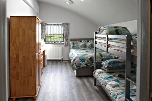 a room with two bunk beds and a window at Aunt Rachel's Barn Hostel in Bushmills