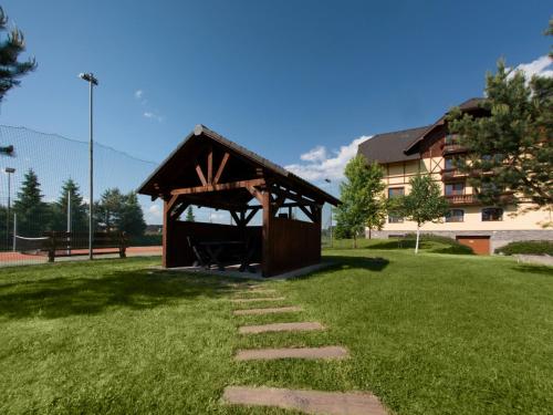 a gazebo in a park with a stone path at TatryView Apartments by KingDubaj PREMIUM in Veľká Lomnica