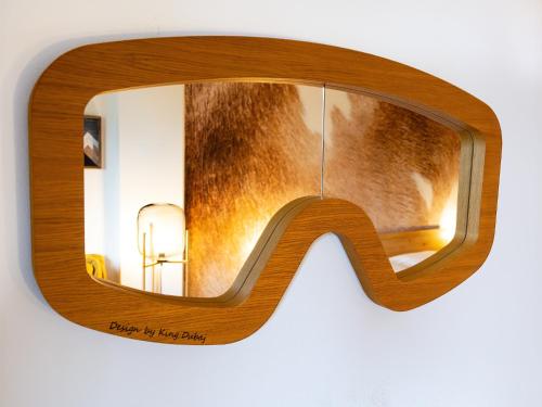 un paio di occhiali da sole di legno appesi a un muro di TatryView Apartments by KingDubaj PREMIUM a Veľká Lomnica