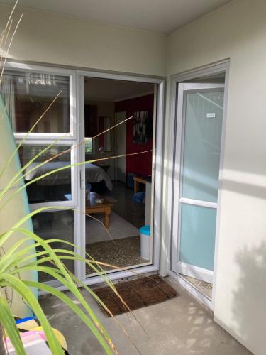 una puerta corredera de cristal con vistas a una habitación en The Back Garden, en Waihi Beach