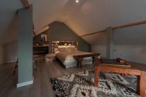 a bedroom with a bed and a table and a rug at Casa Do Ti Gil in Aldeia do Meco