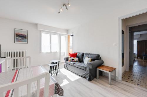 uma sala de estar com um sofá e uma mesa em The Bells - Charming T2 near the Lake em Annecy