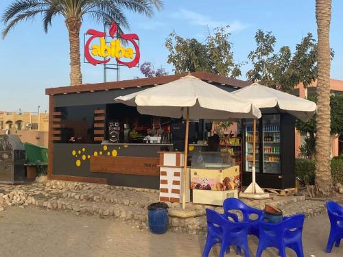 a store with blue chairs and an umbrella at Private chalte Palmera sokhna family in Ain Sokhna
