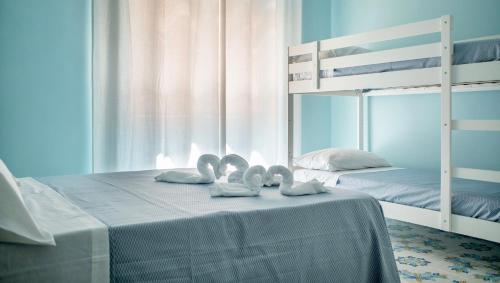 マリーナ・ディ・カメロータにあるB&B Margherita 2の二段ベッド1組付きのベッド1台、タオル2枚