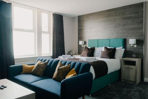 a bedroom with a large bed with a blue couch at The Portland in Ashington